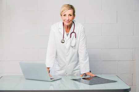 woman doctor standing behind deskの写真素材