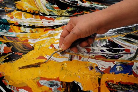 Woman hand painting in yellow  with spatulaの写真素材