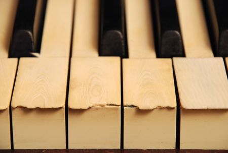 very old wooden piano with ivory keys broken and scratchedの写真素材
