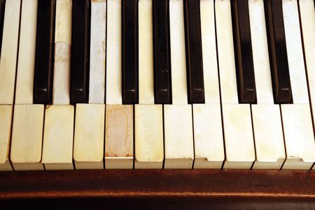 very old wooden piano with ivory keys broken and scratchedの写真素材