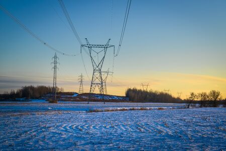 High voltage electricity transmission towers by aerial cables in winterの写真素材