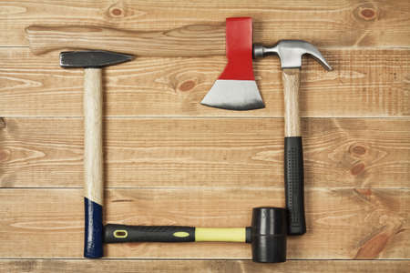 carpenter's hammer and ax on a wooden background