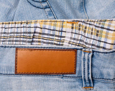 Brown leather jeans label sewed on jeans.