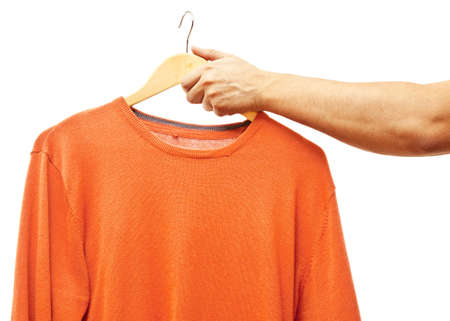 men hand holding hanger with t-shirtの写真素材