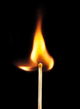 burning matchstick on black background