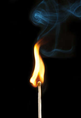 burning matchstick on black backgroundの写真素材
