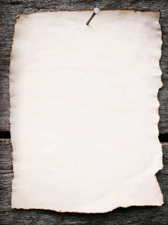 Old paper nailed to a grunge wooden backgroundの写真素材