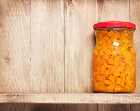 Preserved  carrots on shelf near a brown wooden wallの写真素材