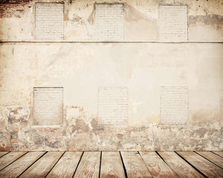Cracked brown brick wall with wooden floor.の写真素材