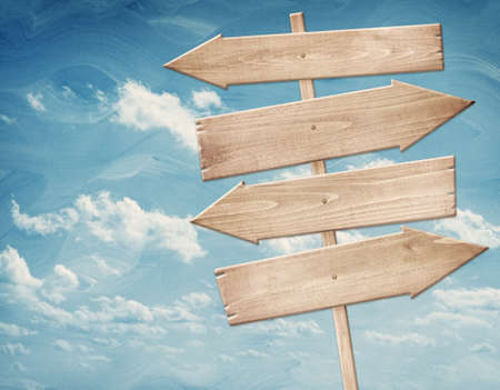Blank brown wooden signpost, arrows against blue sky. Add your own text to the arrowsの写真素材
