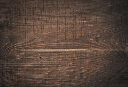 Dark brown scratched wooden cutting board. Wood textureの写真素材