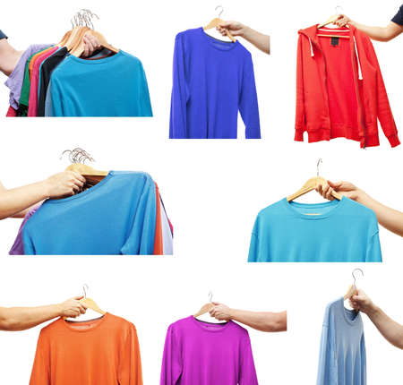 Men hand holding hangers with sweaters, t-shirts, jumperの写真素材