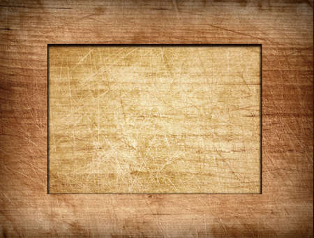 Brown scratched frame on light wooden board.の写真素材