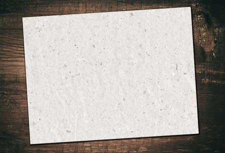 Gray recycled paper is on grunge wooden board.の写真素材