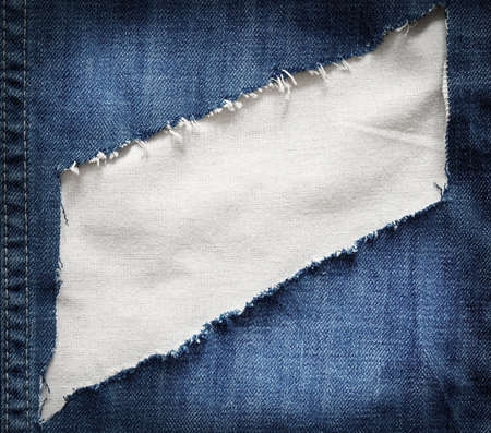 White fabric texture with torn blue jeans.