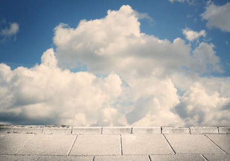 Blue clouds, sky and grunge tile pavement.