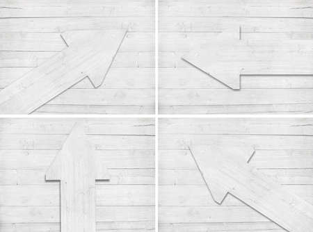 Set of white scratched wooden arrow are on wall.