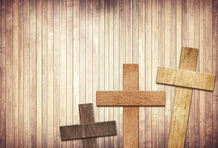 Wooden cross on brown old tabletop or wall surface.の写真素材