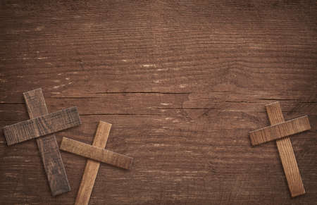 Wooden cross on brown old tabletop or wall surface.の写真素材