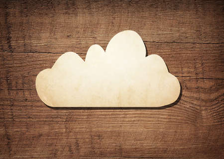 Dark brown scratched wooden board, wood texture with paper cloud symbolの写真素材