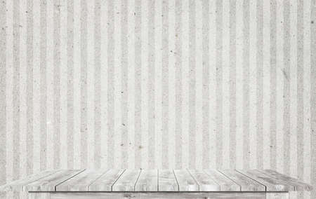White wooden table top near dirty wallpaper.