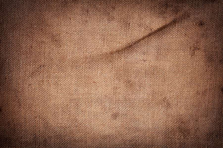 Old stained brown horizontal creasy burlap texture.の写真素材