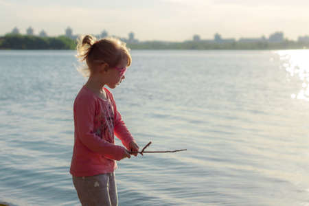 The child runs on the coast in the sand, in clothes.の写真素材