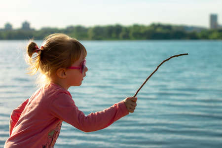 The child runs on the coast in the sand, in clothes.の写真素材