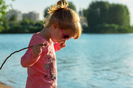 The child runs on the coast in the sand, in clothes.の写真素材