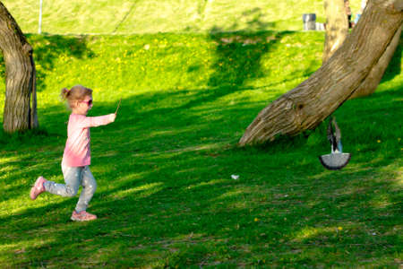 Funny child in glasses playing in a summer park. Happy childhoodの写真素材