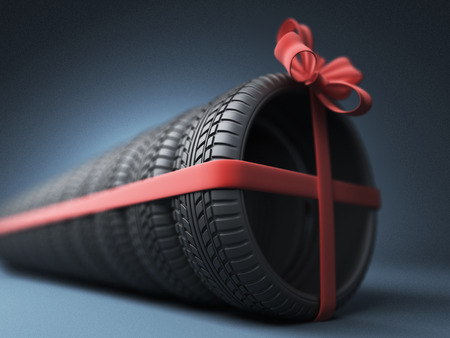 Tire with a red ribbon. Gift. 3D Icon isolated on blue backgroundの写真素材
