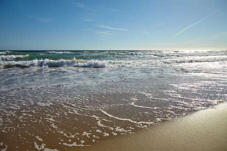 Waves in the ocean and sand on the beach