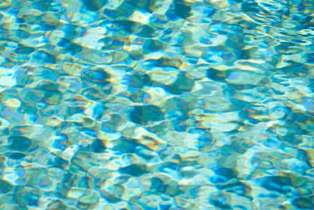 Blue swimming pool rippled water detail. Summer day.
