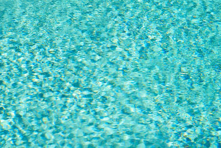 Blue swimming pool rippled water detail. Summer day.