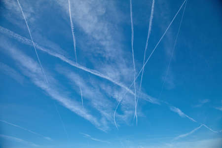 Airplanes flying in the blue sky among clouds and sunlightの写真素材