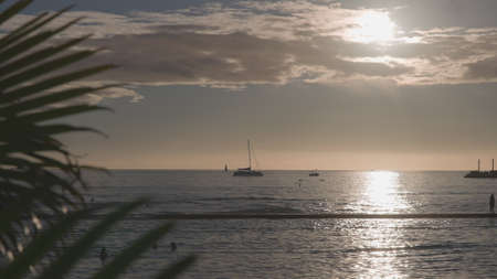 Amazing colors of a tropical sunset. Silhouettes of sailing boats floating on the ocean horizon....