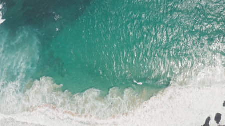 Flying over the ocean at the golden hour. Giant waves foaming and splashing in the ocean. Surfers ride the waves. The turquoise color of the Pacific Ocean water on tropical island of Oahu Hawaii.の写真素材