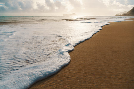 The sandy beach is adorned with waves creating a scenic natural environmentの写真素材