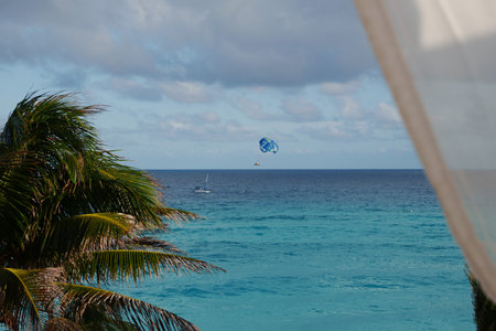 Experience a tropical paradise with thrilling parasailing over vibrant turquoise watersの写真素材