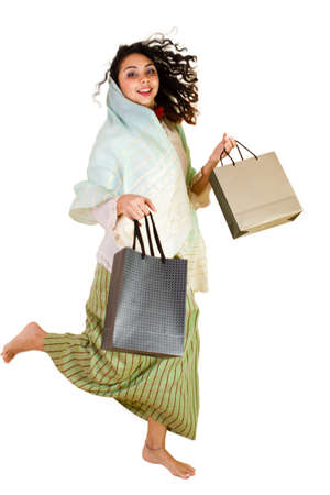 Malaysian lady in traditional dress jumping with shopping bagsの写真素材