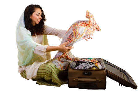 Malaysian lady in traditional dress packing luggageの写真素材