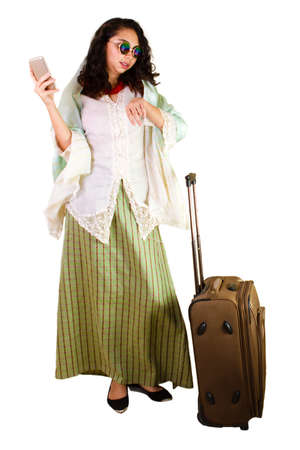 Malaysian lady in traditional dress with luggageの写真素材