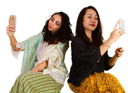 2 Malaysian ladies in traditional dress taking a selfieの写真素材