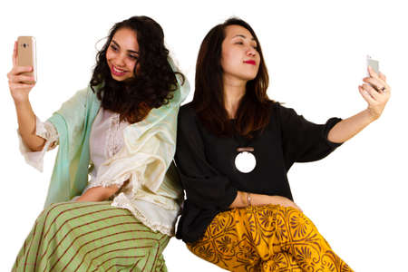 2 Malaysian ladies in traditional dress taking a selfie
