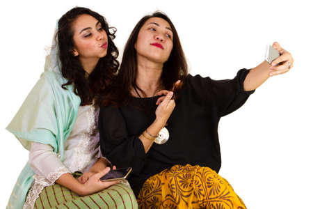 2 Malaysian ladies in traditional dress taking a selfieの写真素材