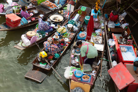 Boats filled with food or tourists at the Ampawa Floating Market in Thailand.の写真素材