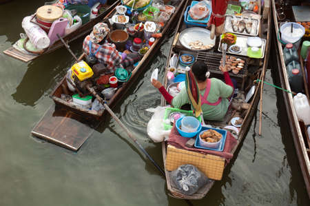 Boats filled with food or tourists at the Ampawa Floating Market in Thailand.のeditorial素材