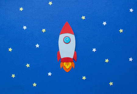 Rocket takes off into space. Cartoon handmade paper art and cutting illustration.の写真素材