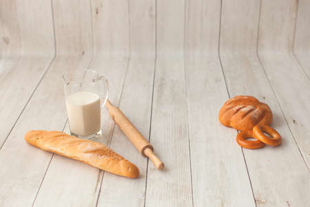 Photo shoot for little cook. Bread and bagels on wooden background.の写真素材