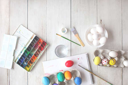 Preparing for Easter. Drawing by watercolor paints. Coloring eggs. Blurred background. の写真素材